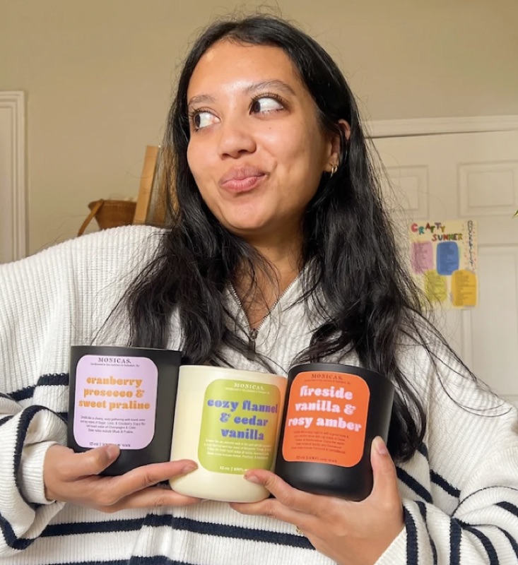Monica Razak holding three of her candles