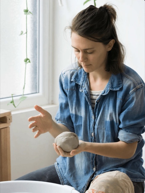 Mia of Pottery to the People shaping a ball of clay