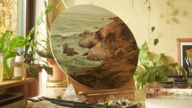 Round seascape oil painting on an easel